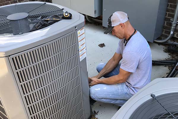 technician servicing air conditioner